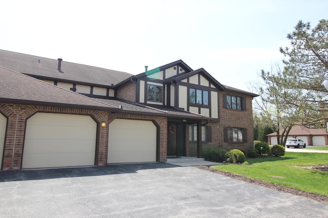 tudor home with a shingled roof, brick siding, and a front yard