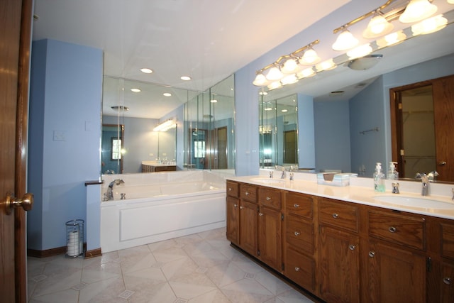 full bathroom featuring double vanity, a bath, recessed lighting, and a sink
