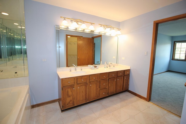 full bath with a sink, double vanity, a washtub, and baseboards