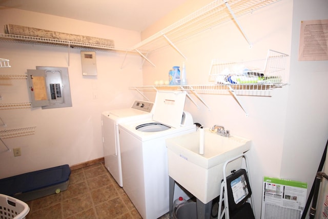 washroom featuring electric panel, a sink, independent washer and dryer, laundry area, and baseboards