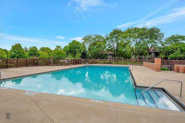 community pool with fence and a patio area