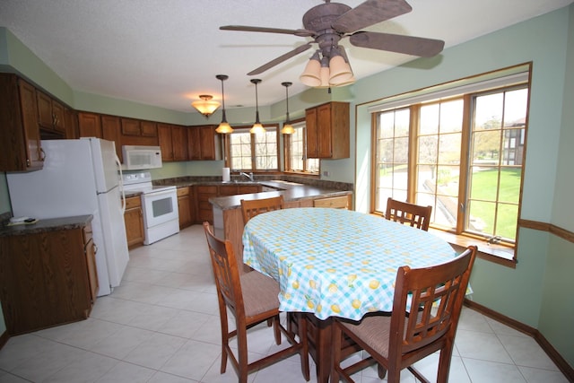 dining room with baseboards, ceiling fan, and light tile patterned flooring
