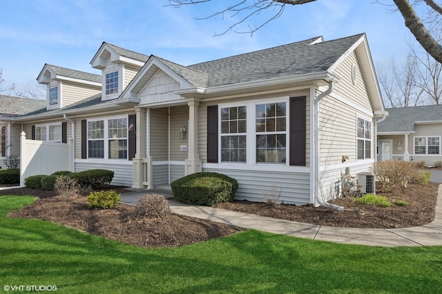 13425 Michigan Ave, Huntley, IL 60142 - cape cod-style house with a front yard, fence, a shingled roof, and central air condition unit