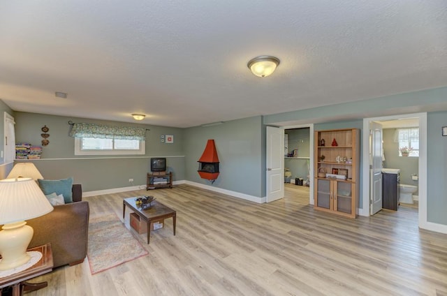 1735 W Woodland Ave, Addison, IL 60101 - living room with light wood-style flooring, a textured ceiling, and baseboards