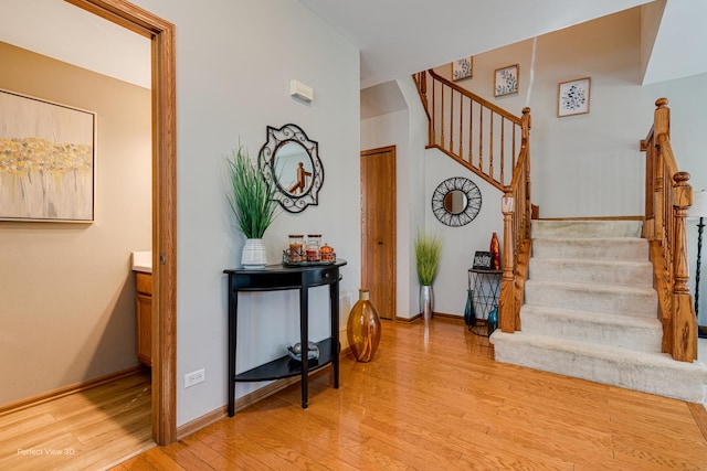 staircase with baseboards and wood finished floors