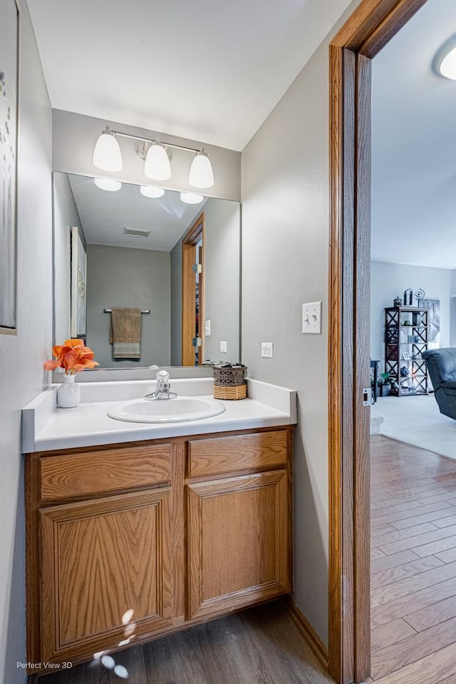 bathroom with wood finished floors, visible vents, and vanity