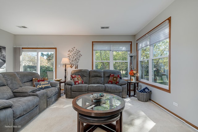 living room with light carpet, visible vents, and plenty of natural light