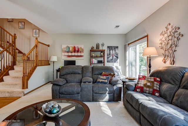 living room featuring baseboards, visible vents, carpet floors, and stairs