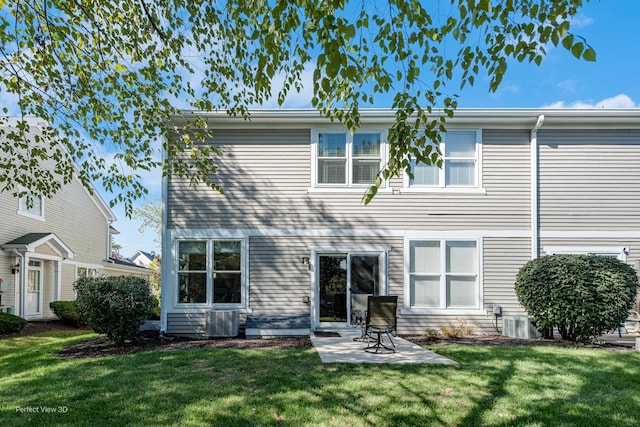 rear view of property with a lawn, central AC unit, and a patio area