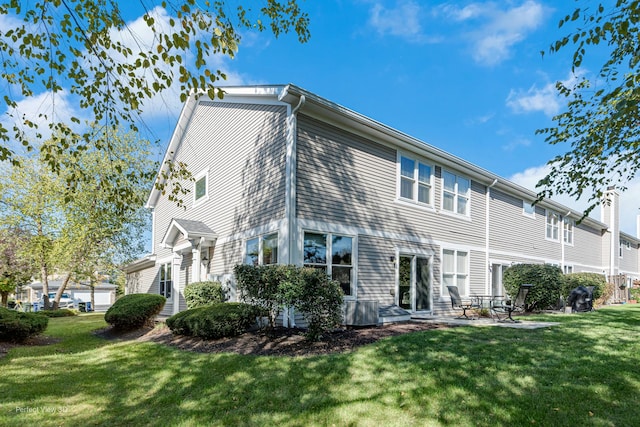 rear view of property featuring a yard and a patio area