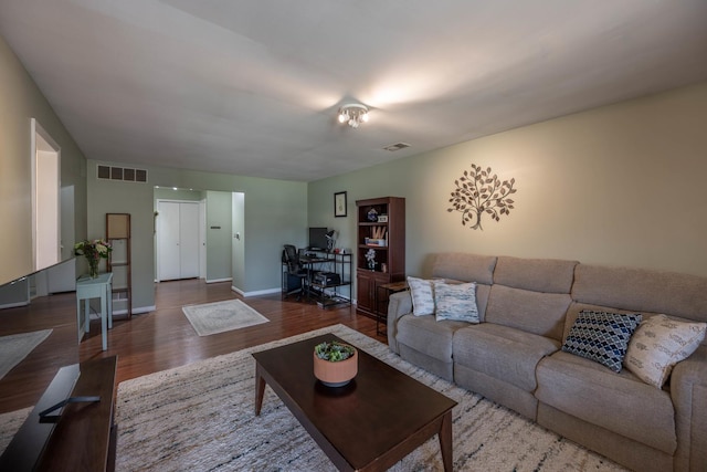 living room featuring baseboards, wood finished floors, and visible vents