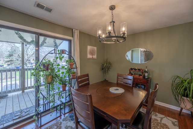 dining room with a chandelier, wood finished floors, visible vents, and a healthy amount of sunlight