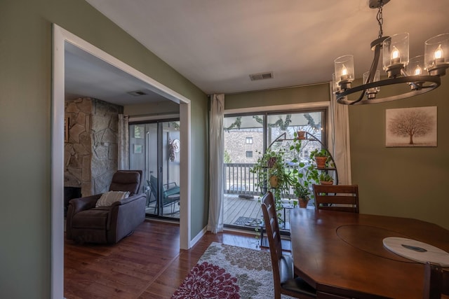 dining space featuring an inviting chandelier, wood finished floors, and visible vents