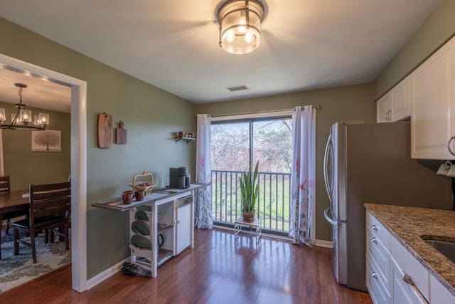 kitchen with dark wood finished floors, stone countertops, baseboards, and white cabinetry