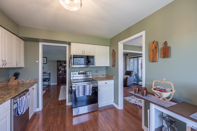 kitchen with stainless steel appliances, baseboards, white cabinetry, light stone countertops, and dark wood-style floors
