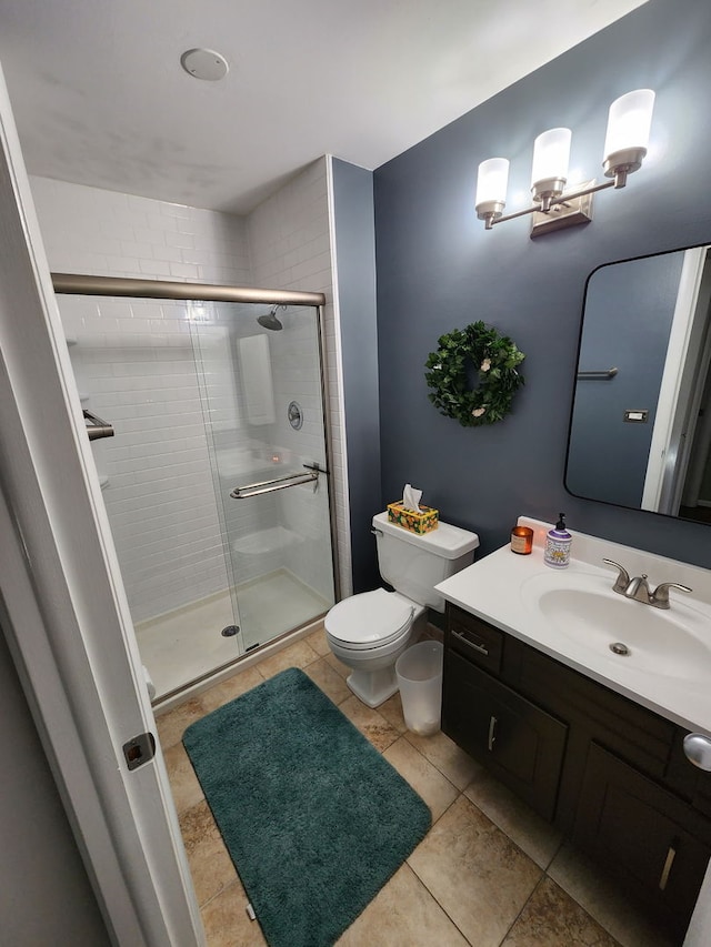 bathroom with tile patterned floors, vanity, a shower stall, and toilet