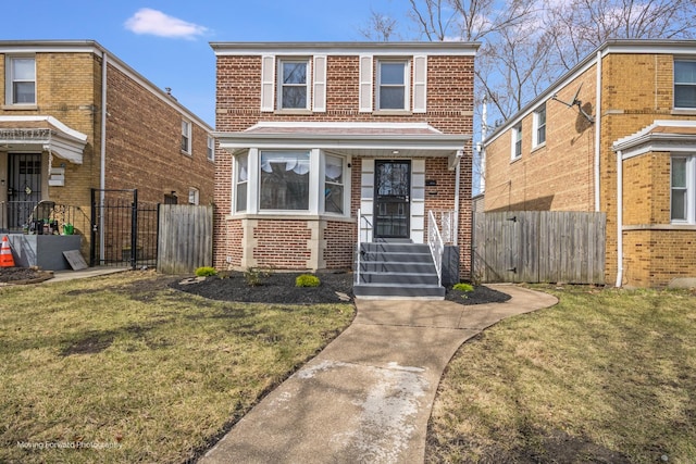 view of front facade featuring brick siding, fence, and a front lawn