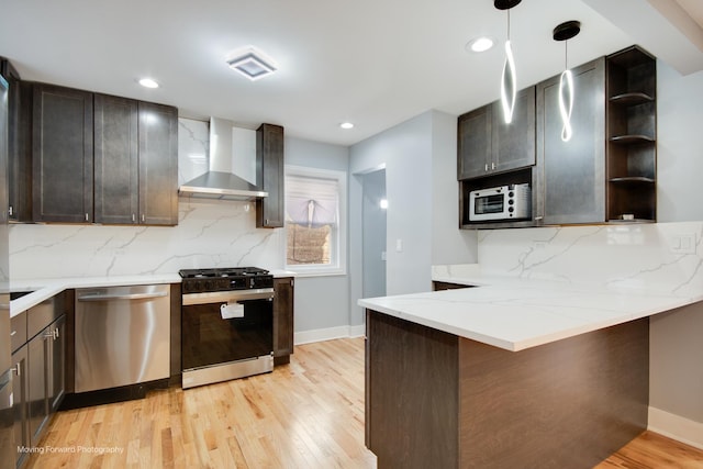 kitchen featuring light wood-style floors, stainless steel dishwasher, wall chimney range hood, open shelves, and range with gas cooktop