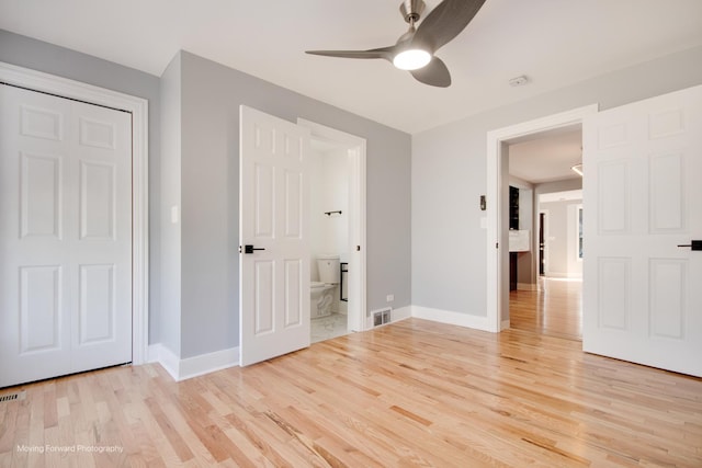 unfurnished bedroom featuring light wood-type flooring, ensuite bathroom, baseboards, and visible vents