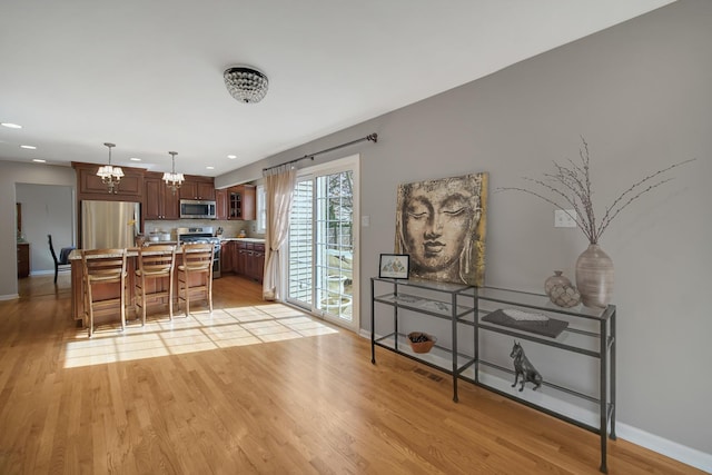 2005 Brentwood Ln, Wheaton, IL 60189 - kitchen with stainless steel appliances, light countertops, baseboards, a chandelier, and a kitchen bar