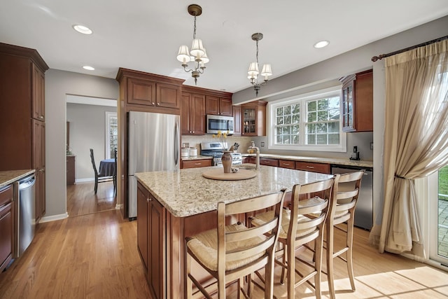2005 Brentwood Ln, Wheaton, IL 60189 - kitchen featuring recessed lighting, light stone counters, stainless steel appliances, light wood-style floors, and glass insert cabinets