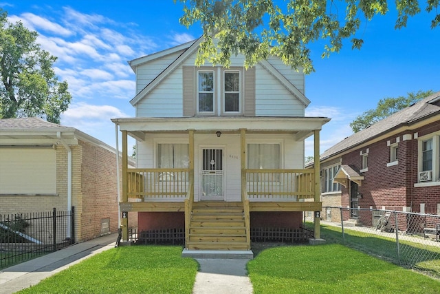view of front of home featuring a front yard, fence, and covered porch