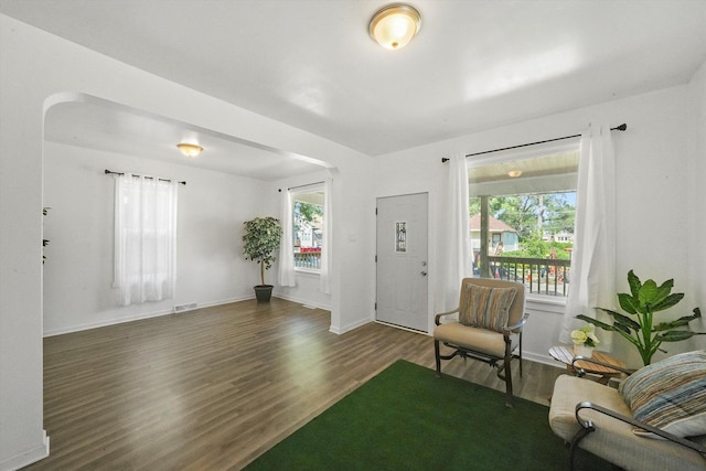 interior space featuring visible vents, baseboards, wood finished floors, and a healthy amount of sunlight
