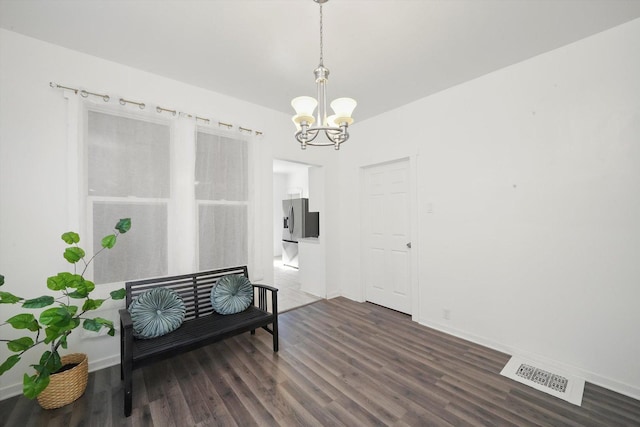 dining space with dark wood-style flooring, visible vents, baseboards, and a notable chandelier