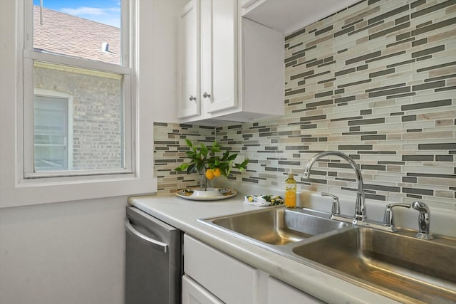 kitchen featuring dishwasher, white cabinetry, a sink, and decorative backsplash