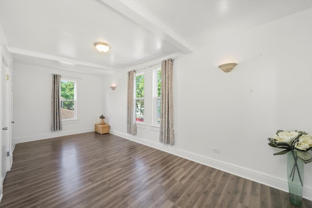 empty room featuring dark wood-type flooring, a healthy amount of sunlight, and baseboards