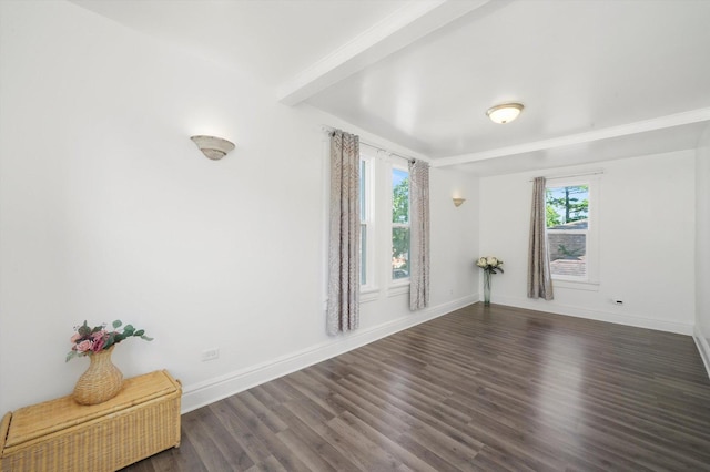 spare room featuring dark wood-style flooring and baseboards