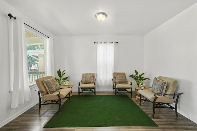 living area featuring dark wood-style flooring and baseboards