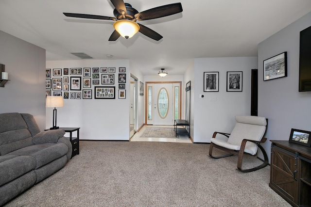 carpeted living area featuring a ceiling fan, baseboards, and visible vents