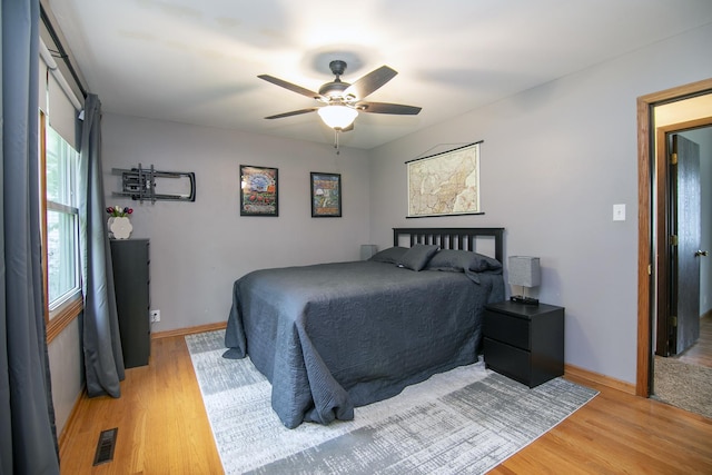 bedroom featuring baseboards, a ceiling fan, light wood-style flooring, and visible vents