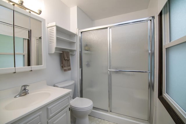 bathroom featuring vanity, toilet, and a shower stall