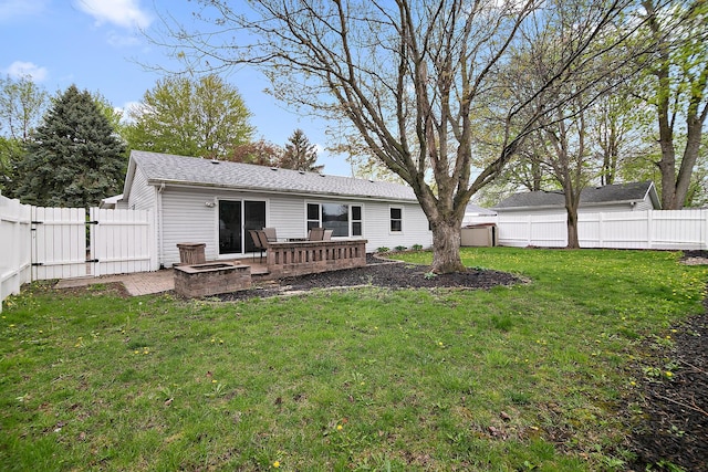 back of house featuring a fenced backyard, a gate, and a lawn