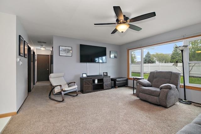 carpeted living area with baseboards, ceiling fan, visible vents, and a wealth of natural light