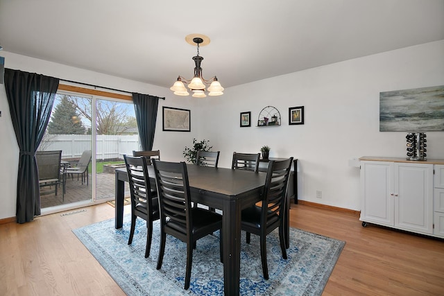 dining room with an inviting chandelier, baseboards, visible vents, and light wood-type flooring
