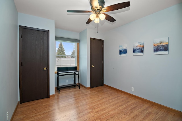 bedroom featuring multiple closets, baseboards, a ceiling fan, and light wood-type flooring