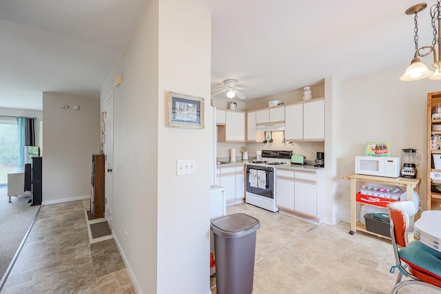kitchen with white cabinets, light countertops, ceiling fan, white appliances, and under cabinet range hood