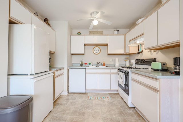 kitchen featuring white appliances, light countertops, a ceiling fan, under cabinet range hood, and a sink