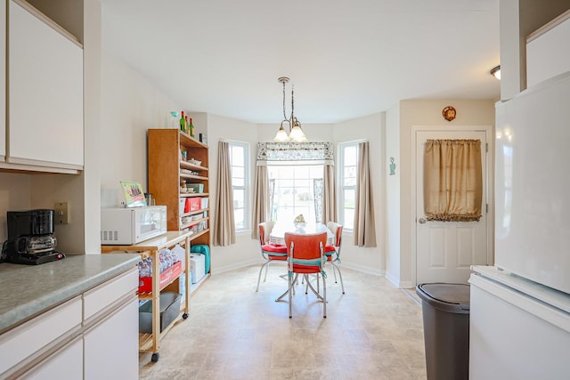 dining area featuring baseboards and a chandelier
