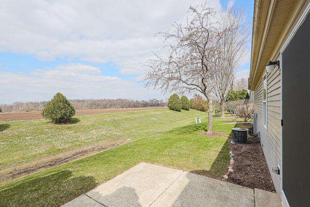 view of yard featuring a rural view and central AC