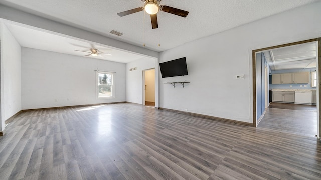 unfurnished living room with baseboards, a textured ceiling, visible vents, ceiling fan, and wood finished floors