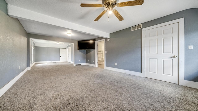 interior space with a textured wall, visible vents, baseboards, and ceiling fan