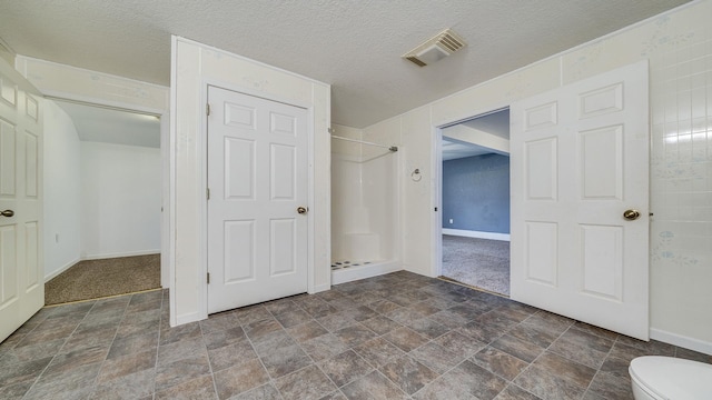 unfurnished bedroom with stone finish floor, visible vents, and baseboards