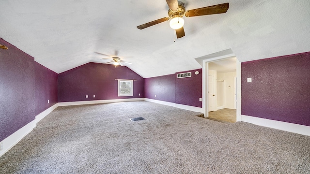 additional living space with visible vents, vaulted ceiling, a ceiling fan, and carpet floors