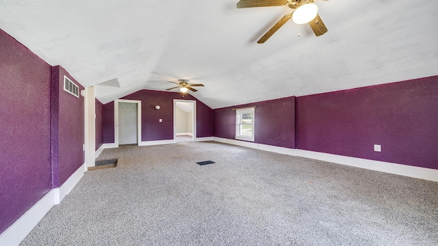 additional living space with visible vents, baseboards, ceiling fan, vaulted ceiling, and carpet flooring