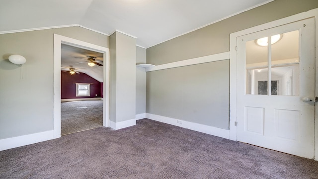 carpeted empty room featuring baseboards, vaulted ceiling, a ceiling fan, and crown molding