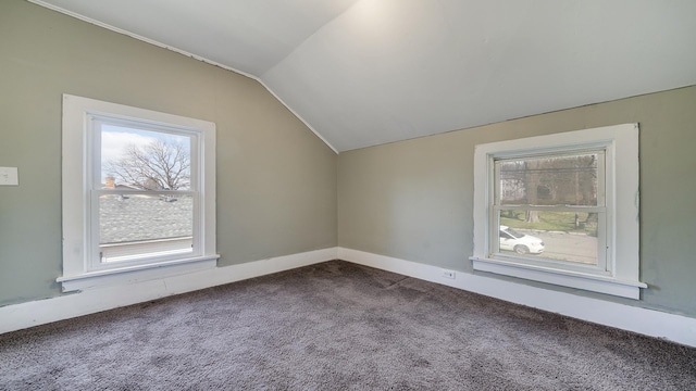 bonus room featuring baseboards, dark colored carpet, and vaulted ceiling